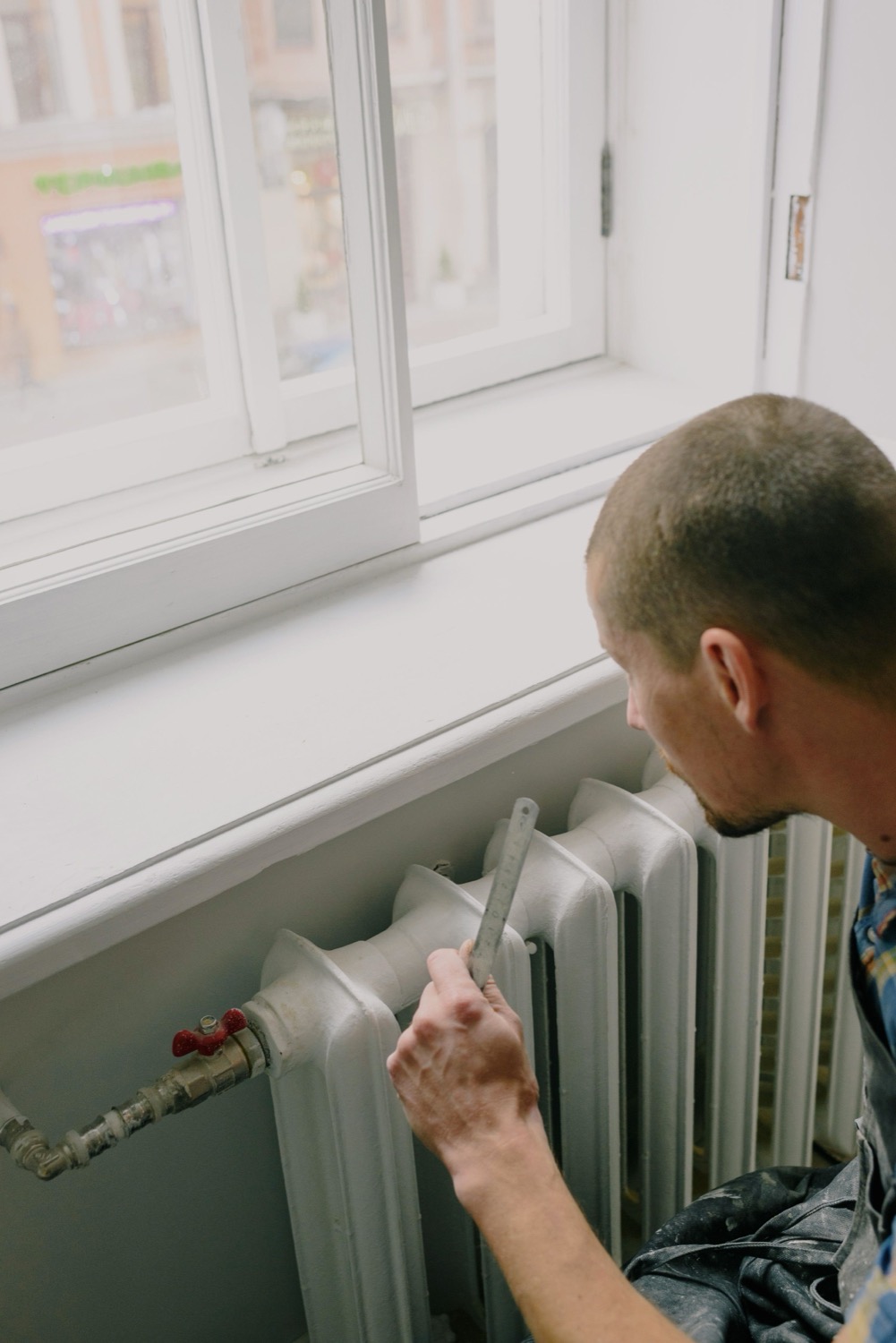 Chauffagiste au travail sur un radiateur